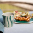 Bio servies Connect van Koziol diner bord-bowl-en beker in Monstera print op tafel met eten