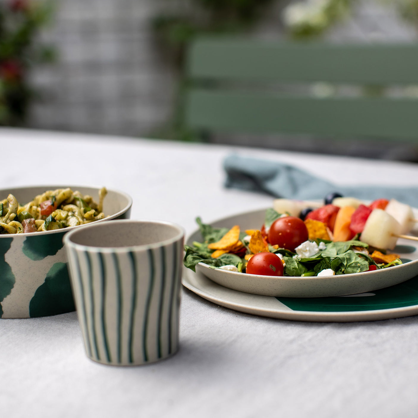 Bio servies Connect van Koziol diner bord-dessert bord-bowl-en beker in Monstera print op tafel