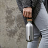 Stainless Steel drinkfles van Black&Blum gedragen aan draaghendel door dame met jeansbroel