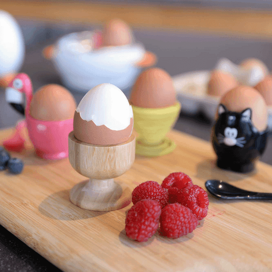 Eierdopje uit bamboe van Point-Virgule op een kleurrijke tafel met gekleurde eierdopjes en frambozen