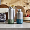 Twee Stainless steel drinkflessen groot en klein van Black & Blum op een keukenblad