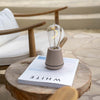 Humble One lamp beige op een boek op een houten tafel met houten stoel