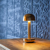 Gouden Humble Two lamp op houten tafel met blauwe structuur achtergrond