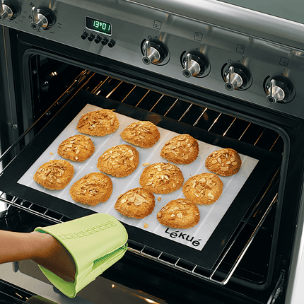 Rechthoekige bakmat uit silicone en glasvezel van Lékué met gebakken koekjes die uit oven geschoven worden