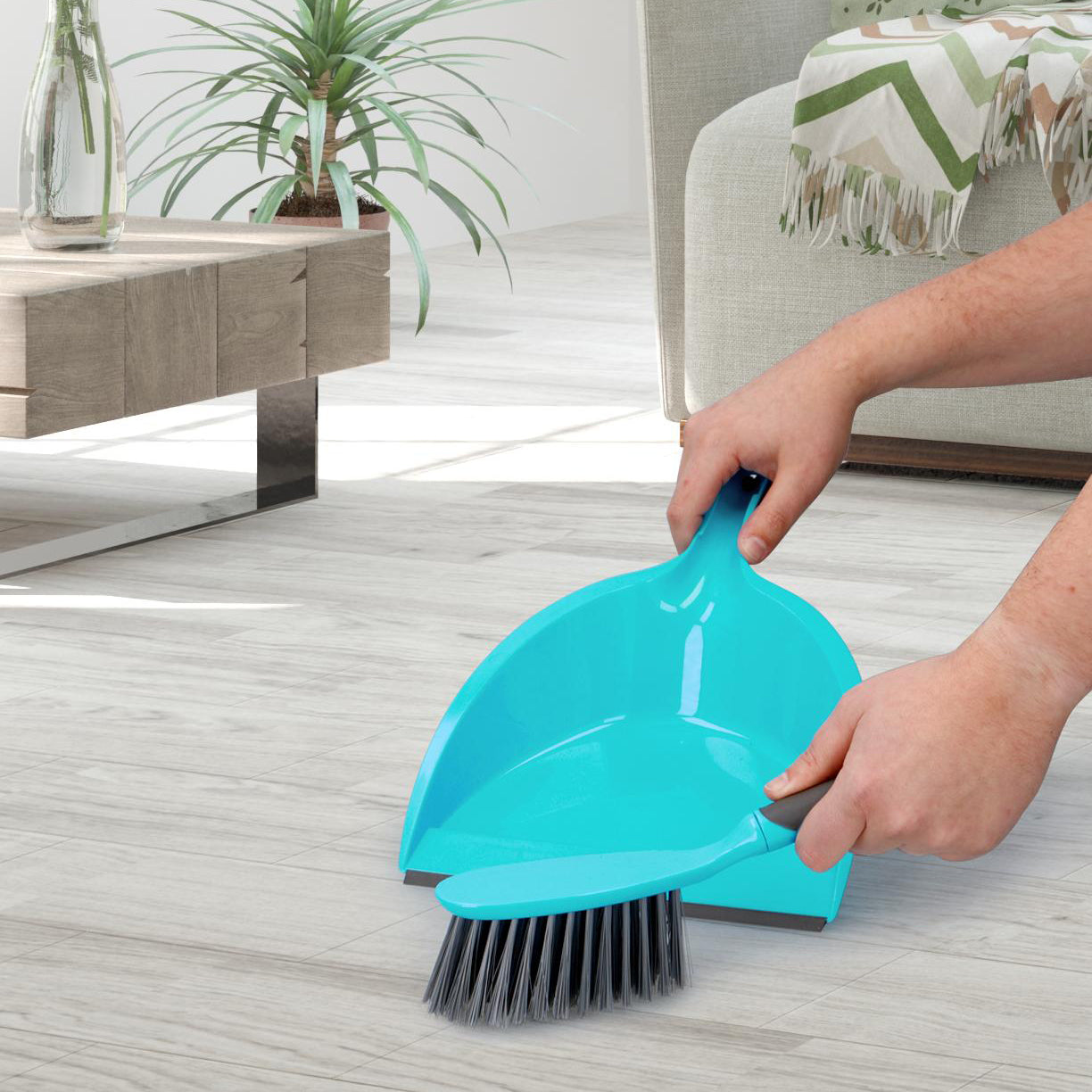 borstel en blik kleur blauw met grijs in gebruik op houten vloer 