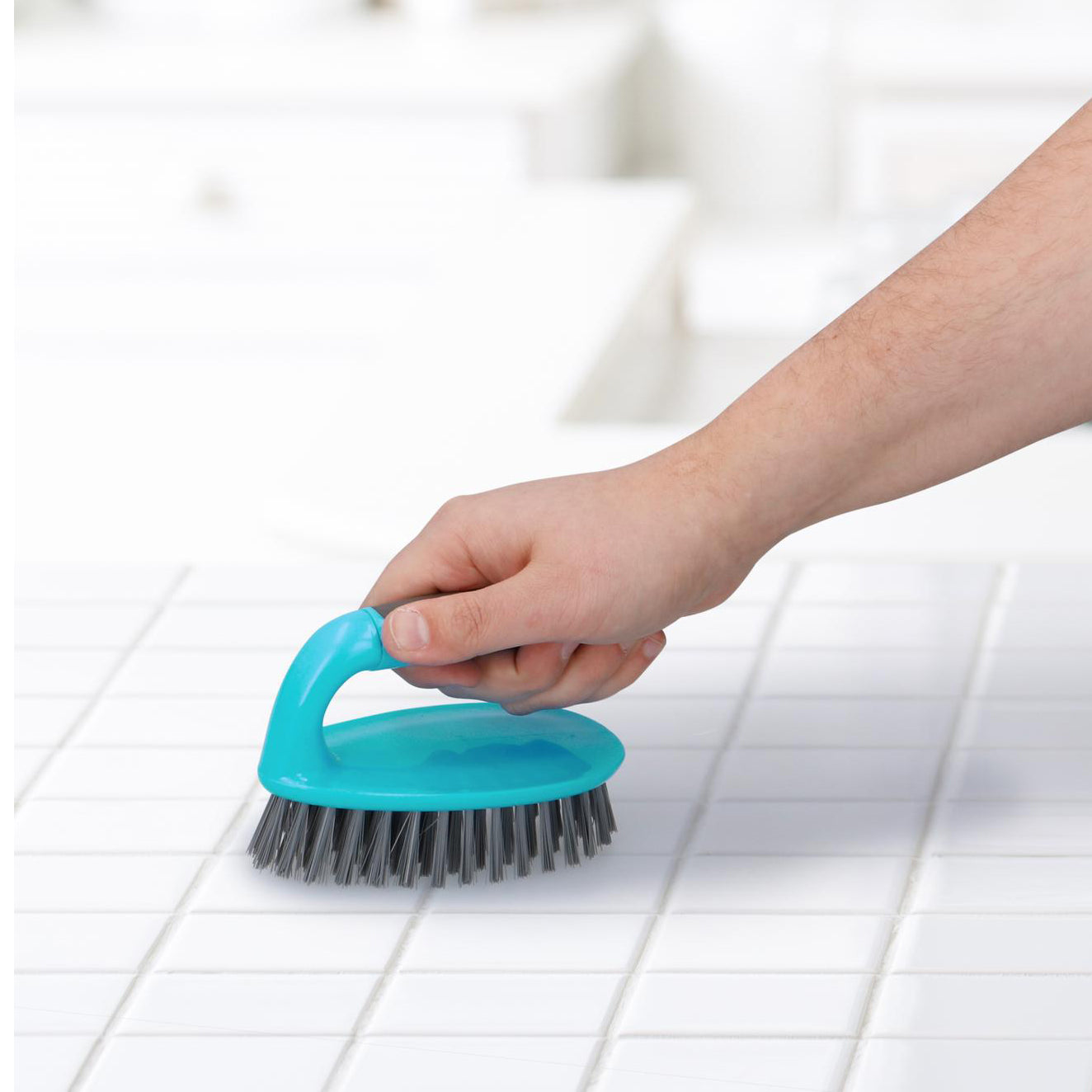 een blauwe schrob borstel waarmee tegels worden afgewassen 