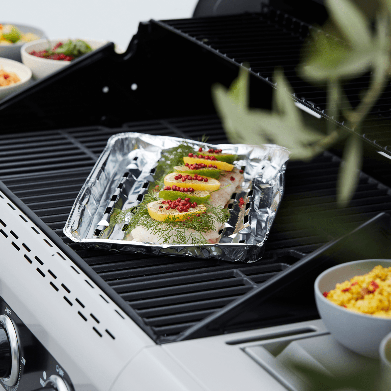 Aluminium BBQ schaal op BBQ met een witte vis met dille en citroen