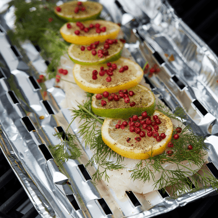 Aluminium BBQ schaal op BBQ met een witte vis met dille en citroen