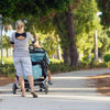 zwarte Telefoonhouder op buggy geklemd met kind erin tijdens een wandeling in het park 