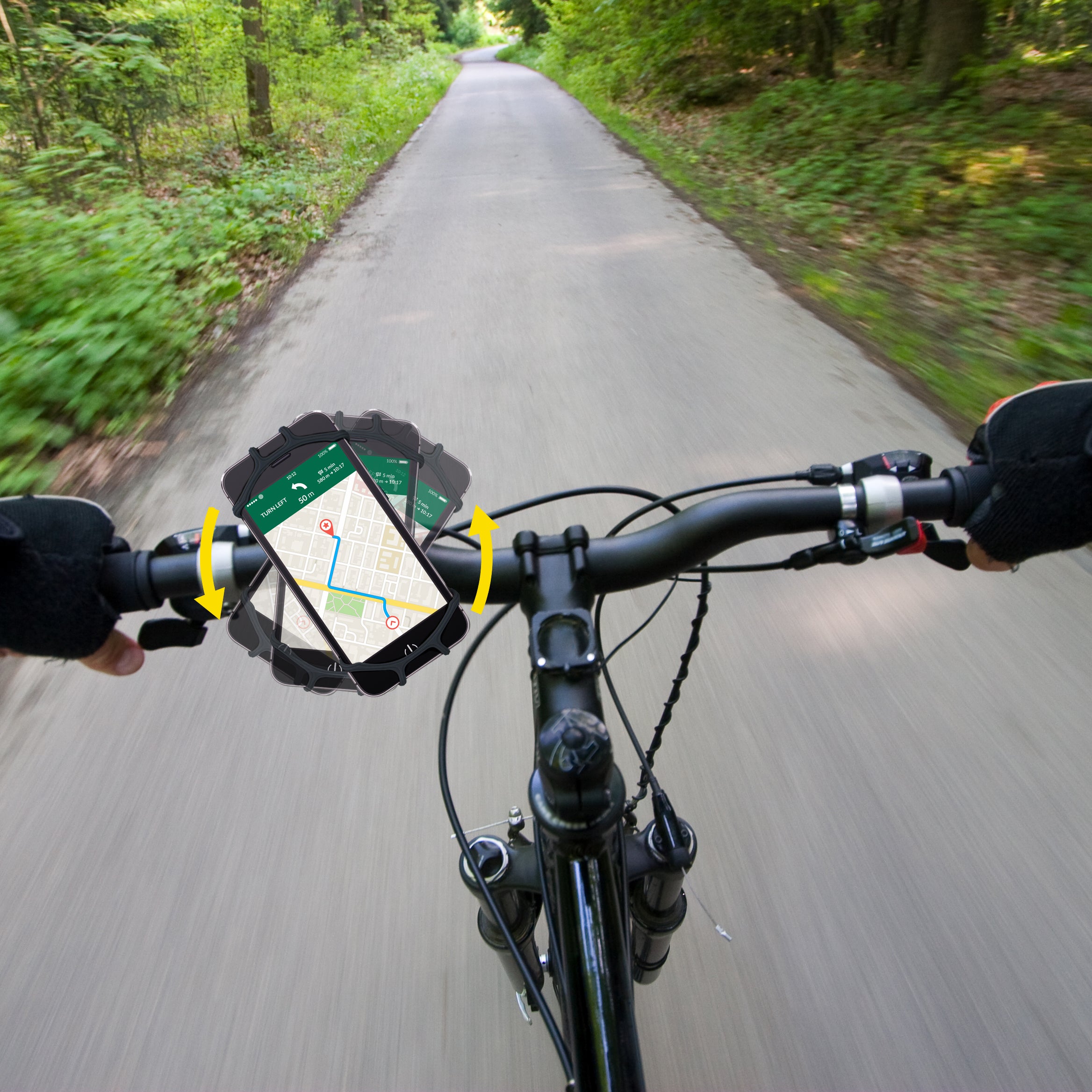 zwarte Telefoonhouder voor fiets met telefoon erop geklemd terwijl rijdend op een straat tussen de bossen 